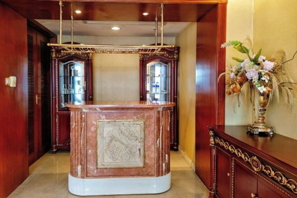 A reception area with a marble counter, two glass-fronted doors, and a decorative vase with flowers.