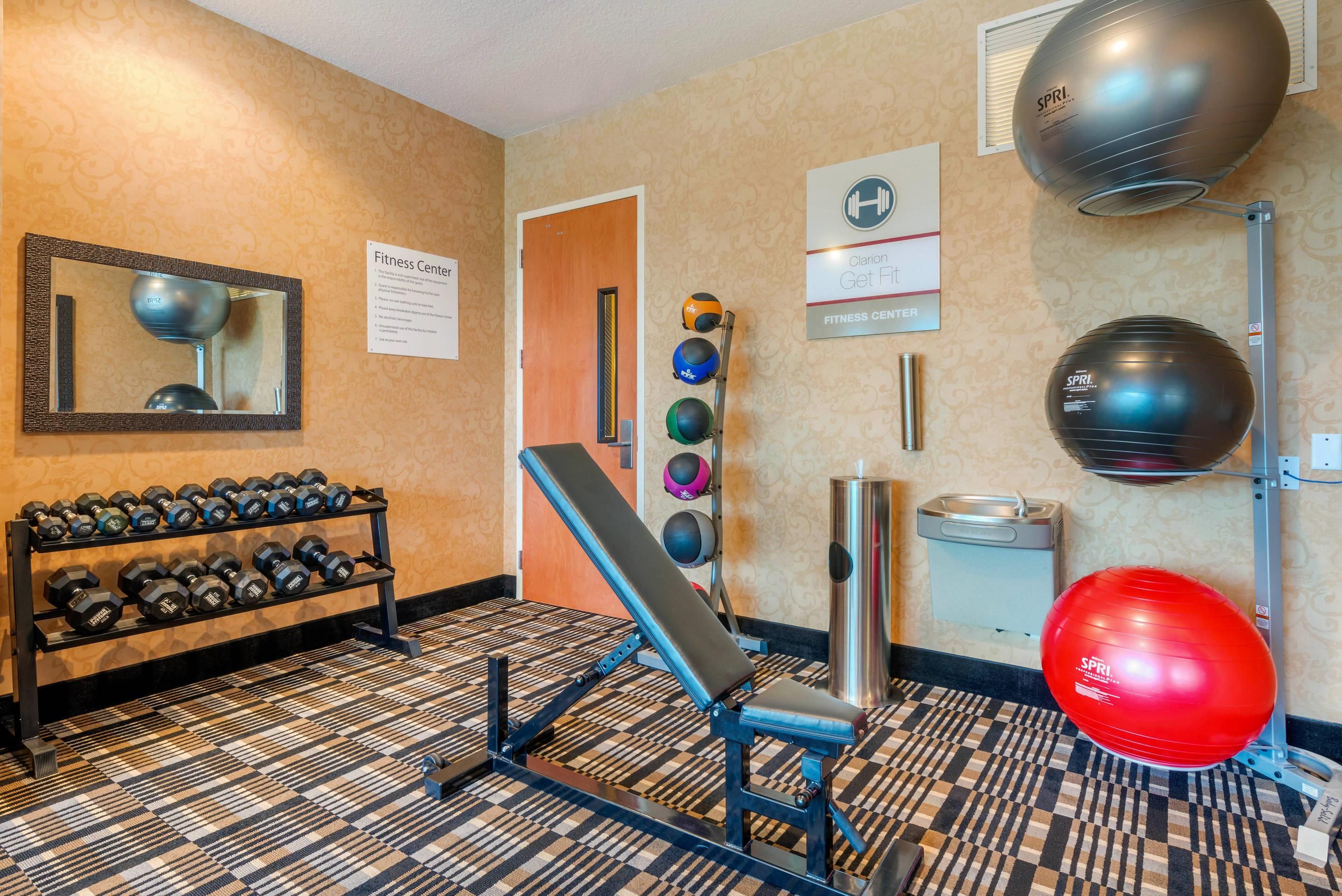 Un gimnasio con equipo de ejercicio, un espejo y un cartel.