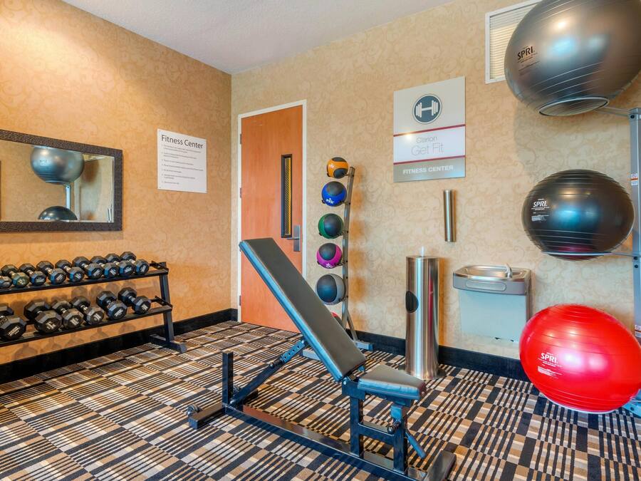 A fitness center with exercise equipment, a mirror, and a sign.