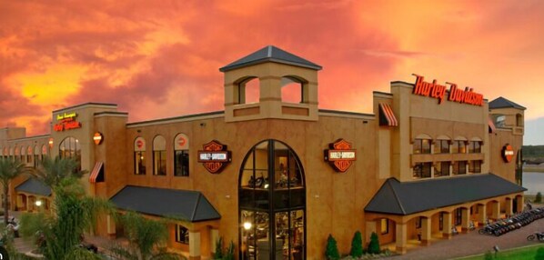 A Harley-Davidson branded building with a large arched entrance, multiple windows, and a parking area in front. - Clarion Inn Ormond Beach at Destination Daytona (Ormond Beach)