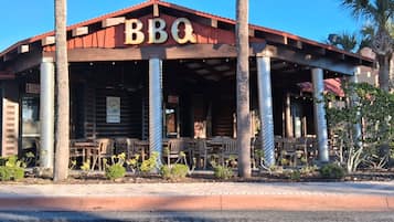 En restaurang som serverar grillmat, med uteservering och ett rött tak.