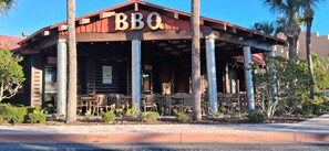 A BBQ restaurant with outdoor seating and a red roof. - Clarion Inn Ormond Beach at Destination Daytona (Ormond Beach)