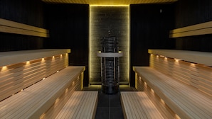 Una sauna con bancos de madera y un pilar de piedra central.
