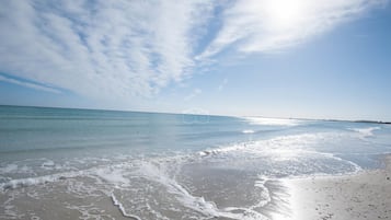 Playa privada, playa de arena blanca, camastros y sombrillas