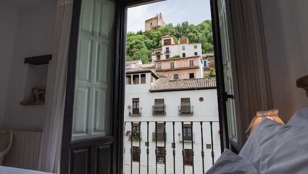 A hotel room with a view of a cityscape, including buildings and a hill. - Hotel Rosa D´Oro (Granada)