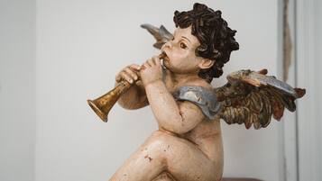A statue of a cherub with wings and a trumpet.