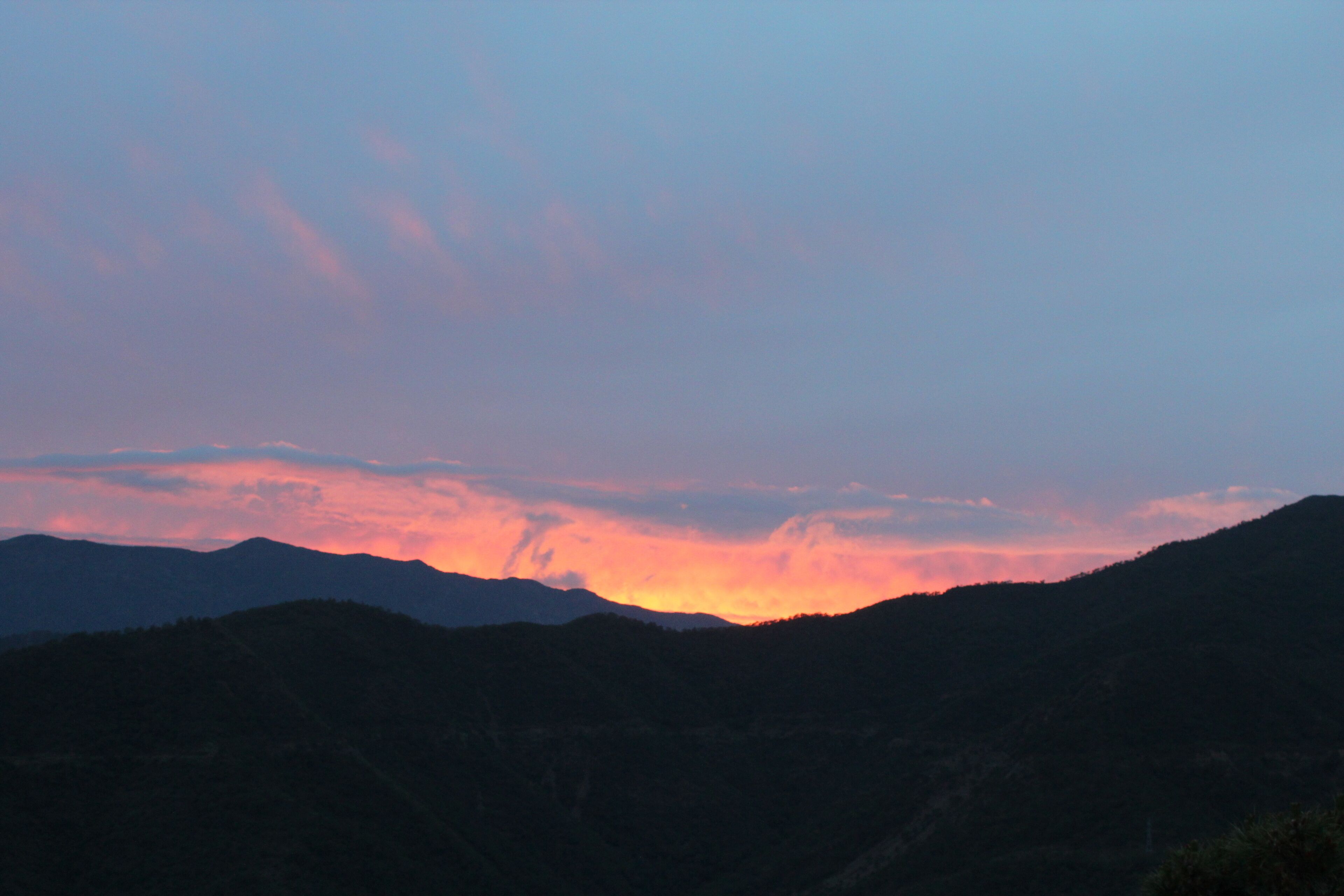 Paisaje montañoso durante la puesta de sol con cielo despejado.