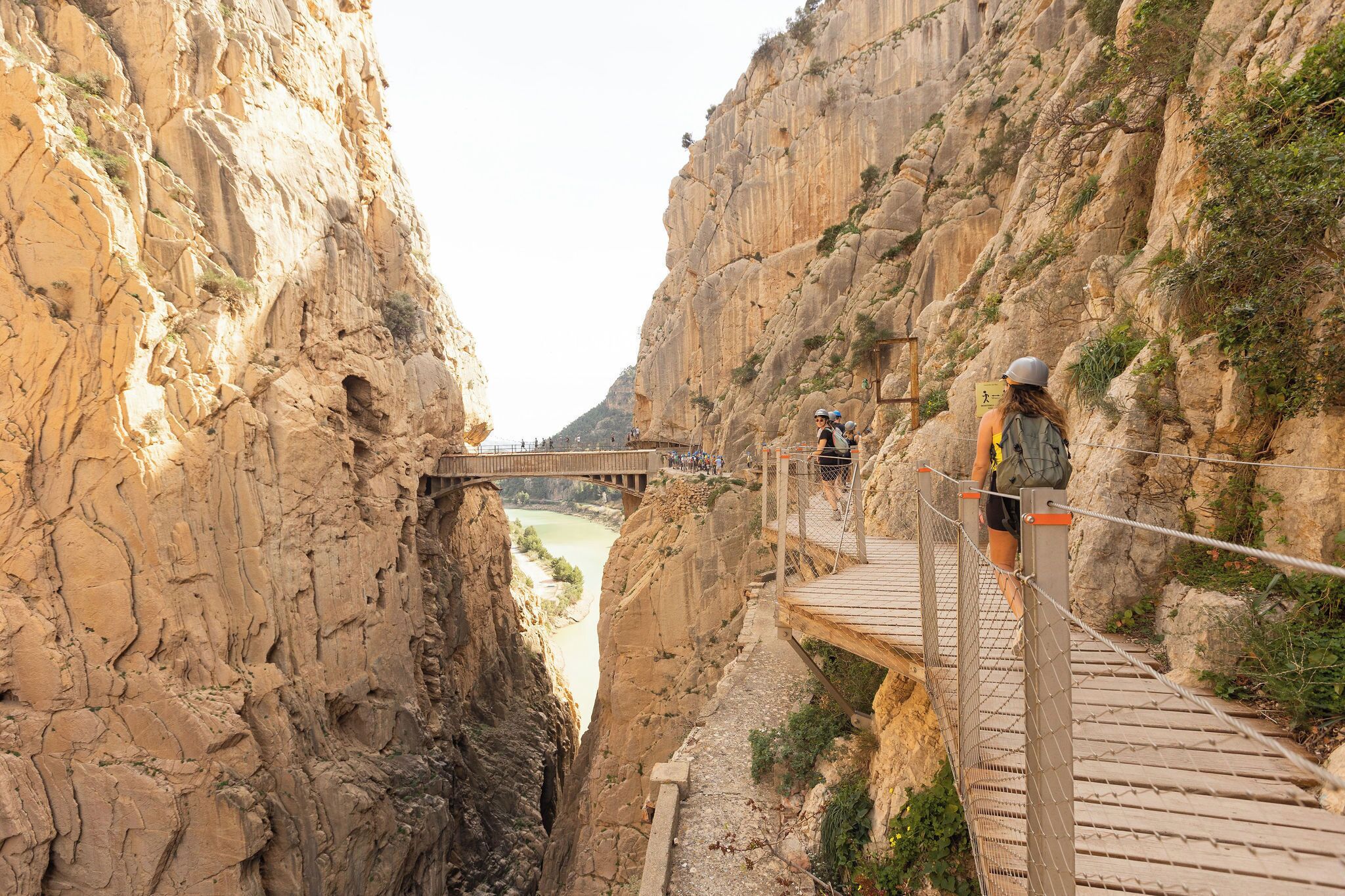 A wooden suspension bridge over a canyon with a river below.