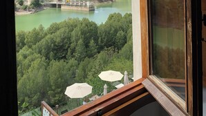 A view from a window overlooking a river, mountains, and a bridge. - Complejo Turístico Rural La Garganta (Álora)
