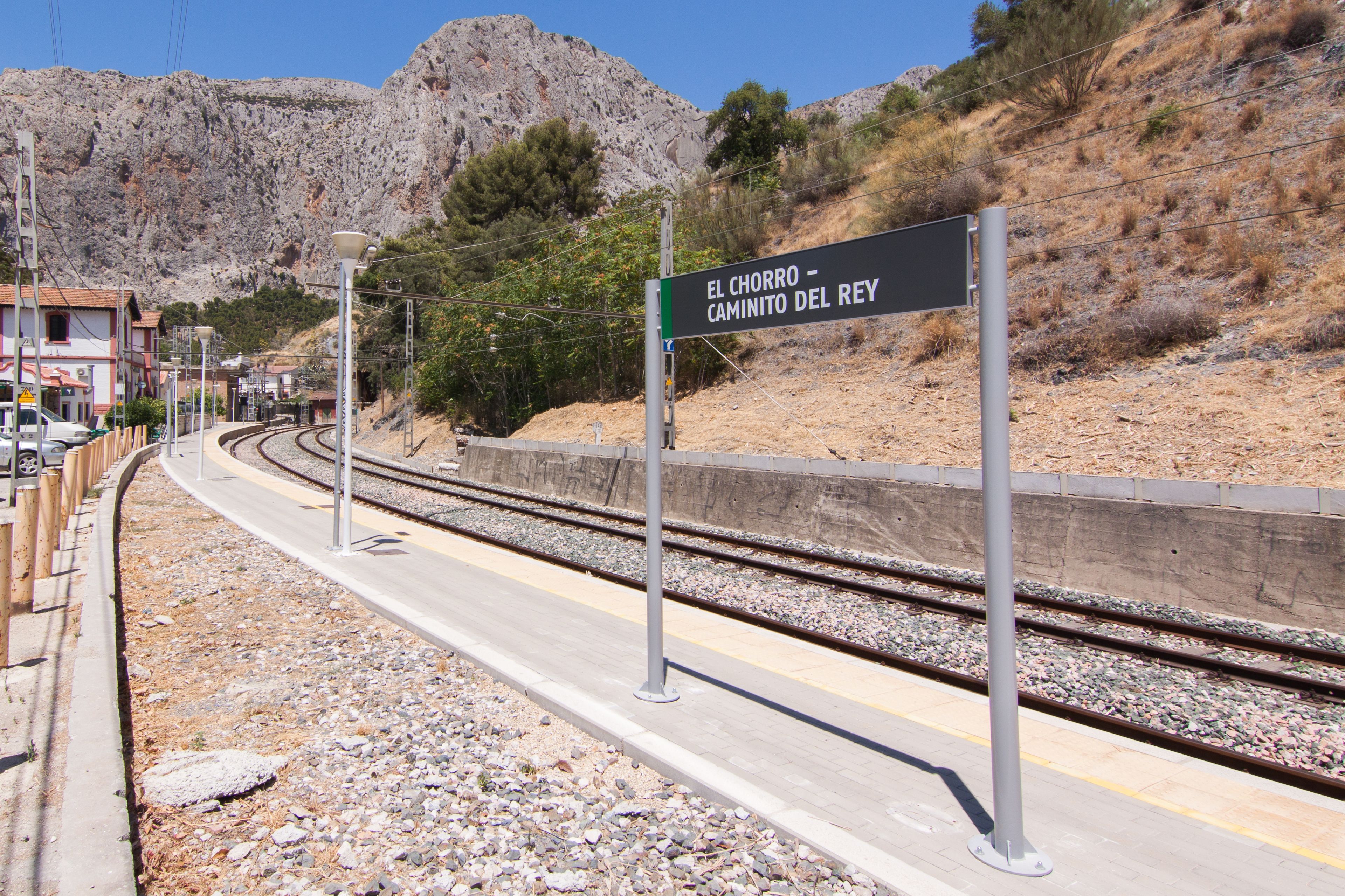 Andén de estación de tren con un cartel que dice 'El Chorro - Camino del Rey'.