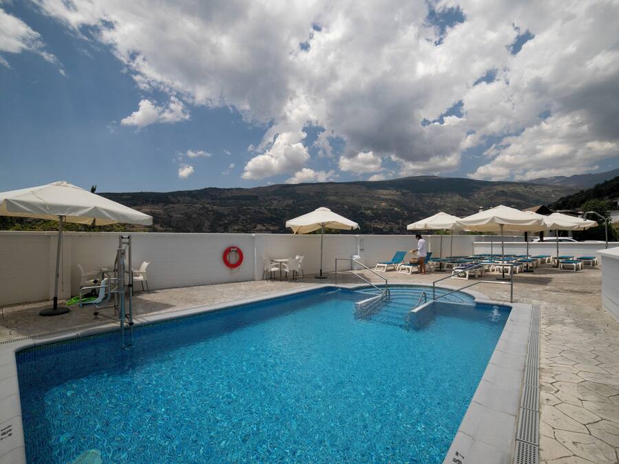 Una piscina al aire libre de temporada, sillones reclinables de piscina