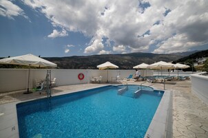 Una piscina al aire libre de temporada, tumbonas