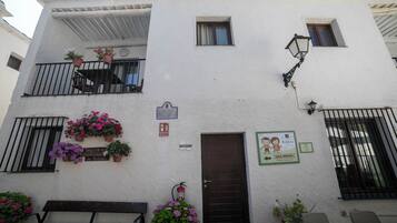 Un edificio con balcón, una puerta y un letrero que indica una sala de juegos para niños.