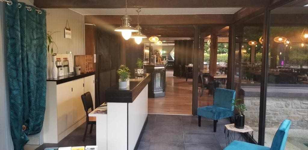 A restaurant with a counter, seating area, and a view of the outdoors.