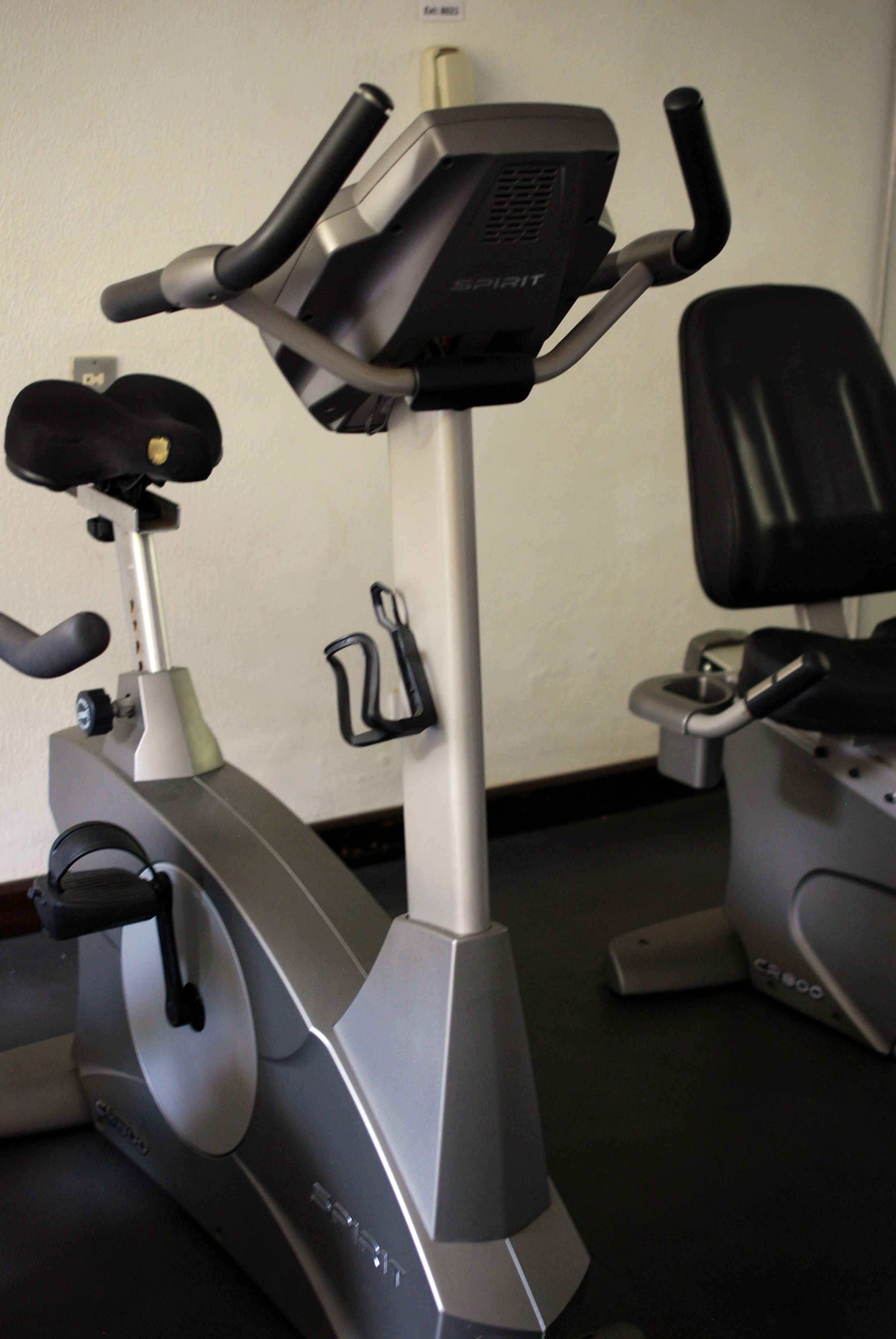 Ein stationäres Ergometer mit Bedienfeld, Sitz und Lenker.
