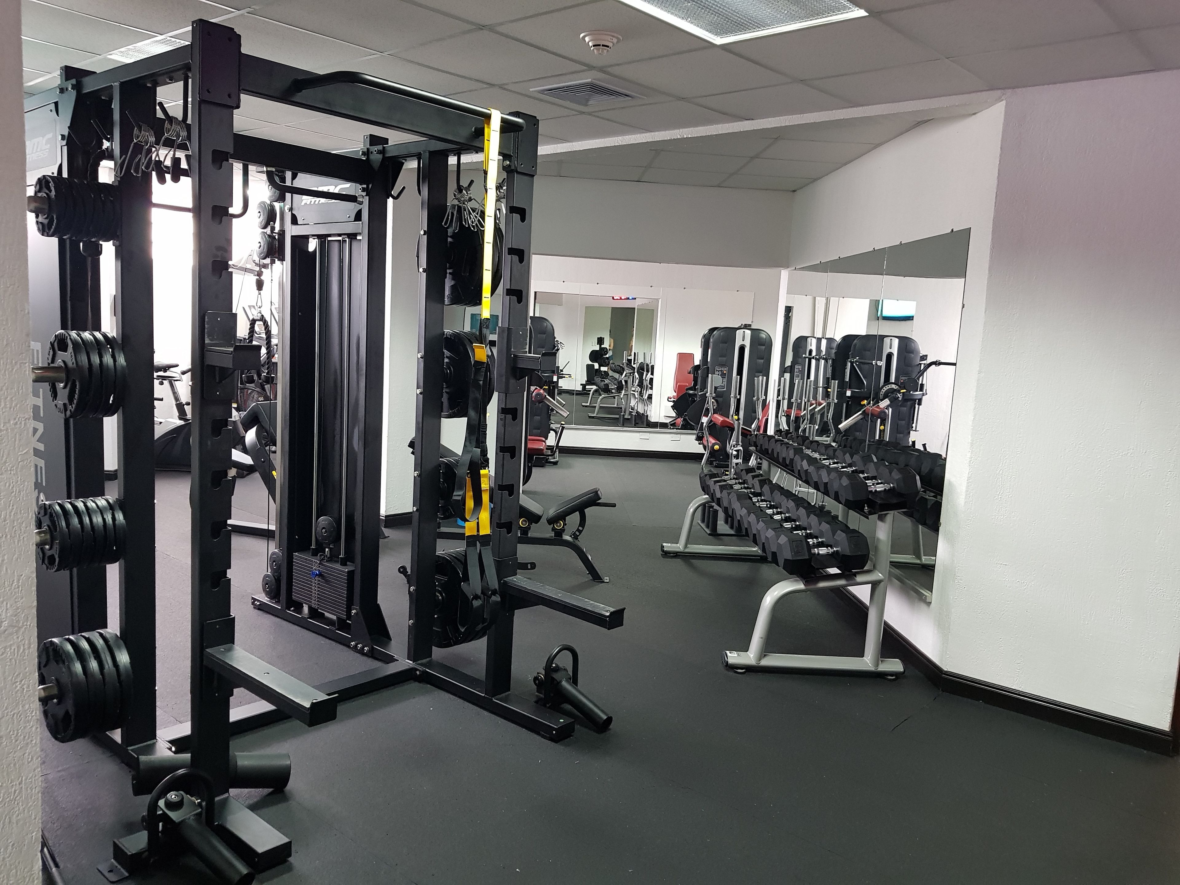 A gym with weightlifting equipment, treadmills, and exercise machines.