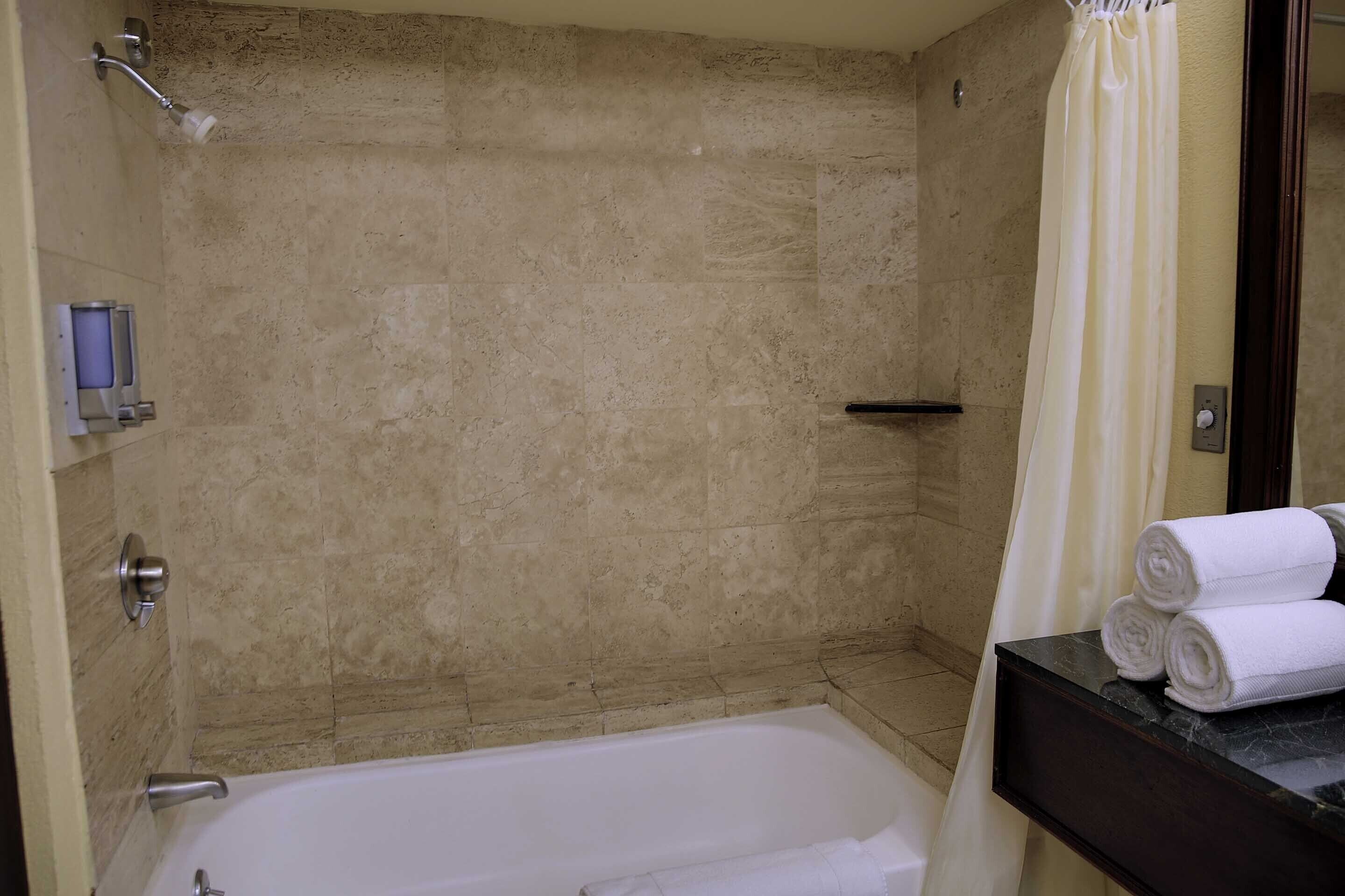 Un baño con bañera, ducha e inodoro.