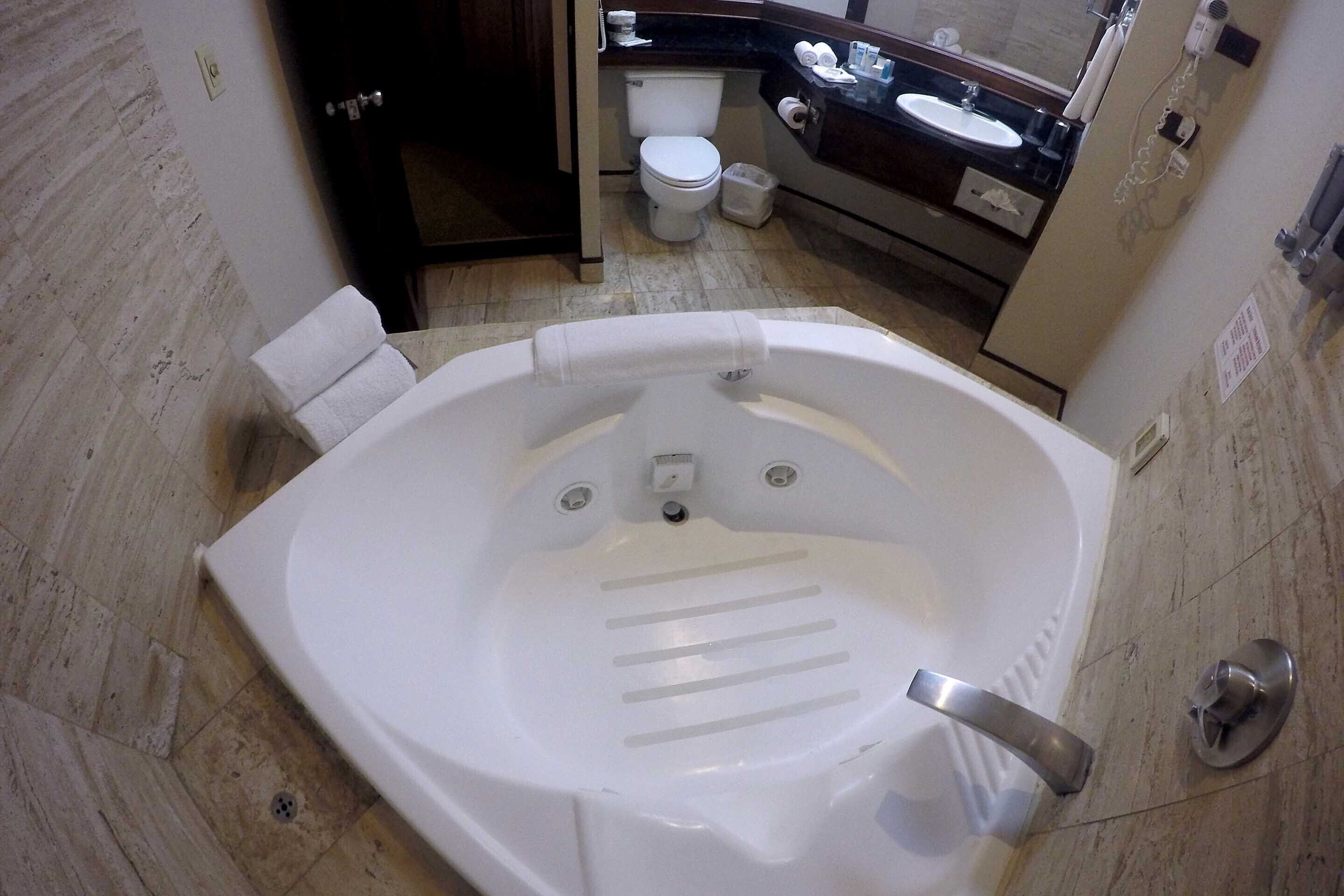 Un baño con una bañera grande, un inodoro y un lavabo.