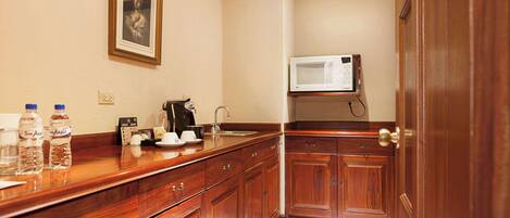 A kitchen with wooden cabinets, a microwave, and a coffee maker.