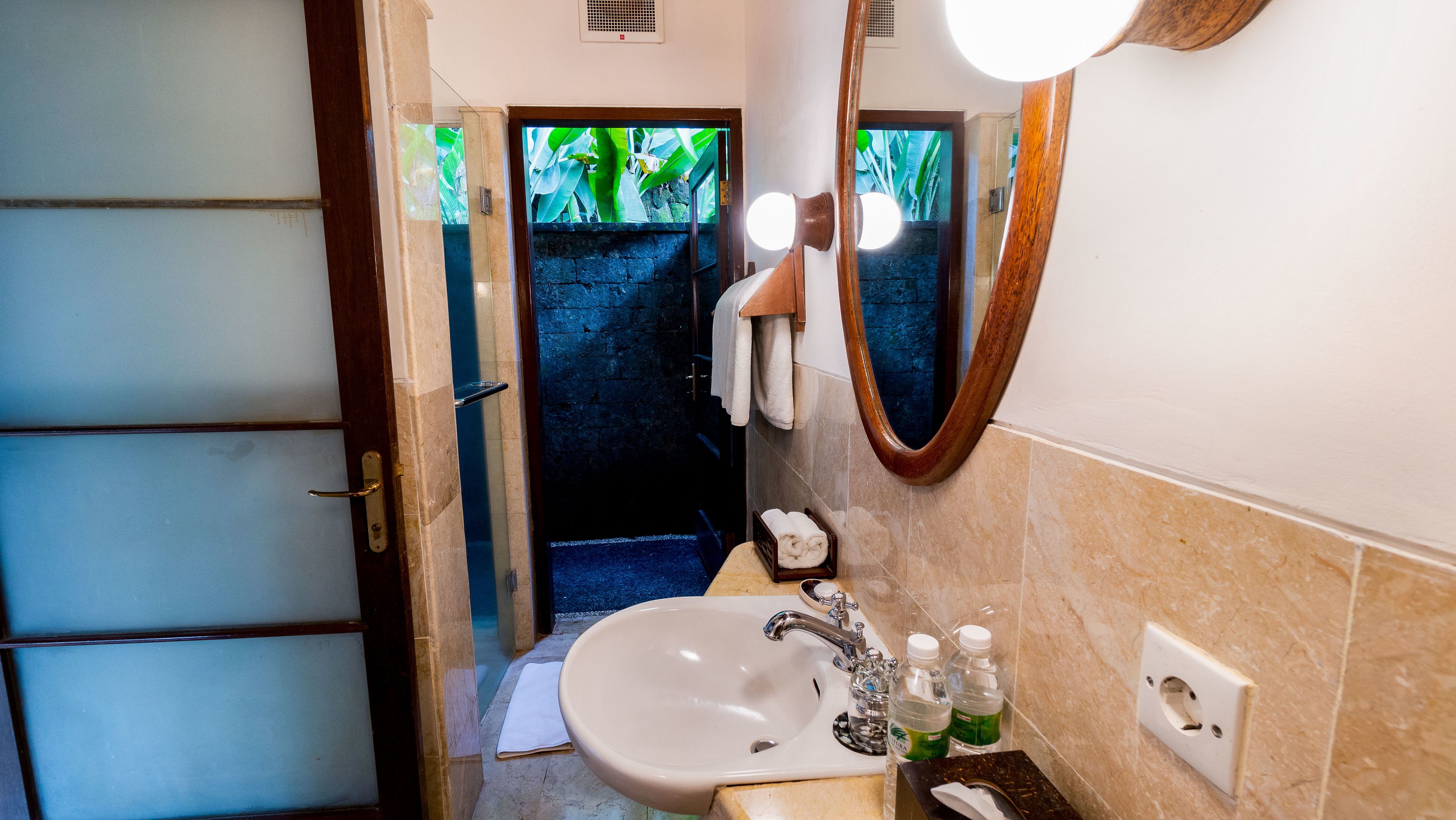 A bathroom with a sink, mirror, and towel rack.