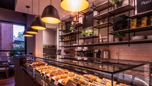 Mostrador de panadería con diversos productos horneados y una estación de café.