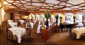 A restaurant with multiple tables, chairs, and a grand piano. - Estelar Apartamentos Bogotá - La Fontana (Bogotá)