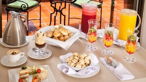 Una tavola imbandita per la colazione, con diversi cibi, bevande e una caraffa di caffè.