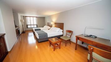 Une chambre d’hôtel équipée d’un lit, d’un bureau, d’une chaise, d’une lampe et d’un téléphone.
