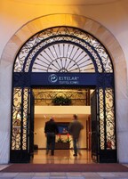 Entrada a Estelar Suites Jones, con una reja metálica arqueada y un letrero arriba.