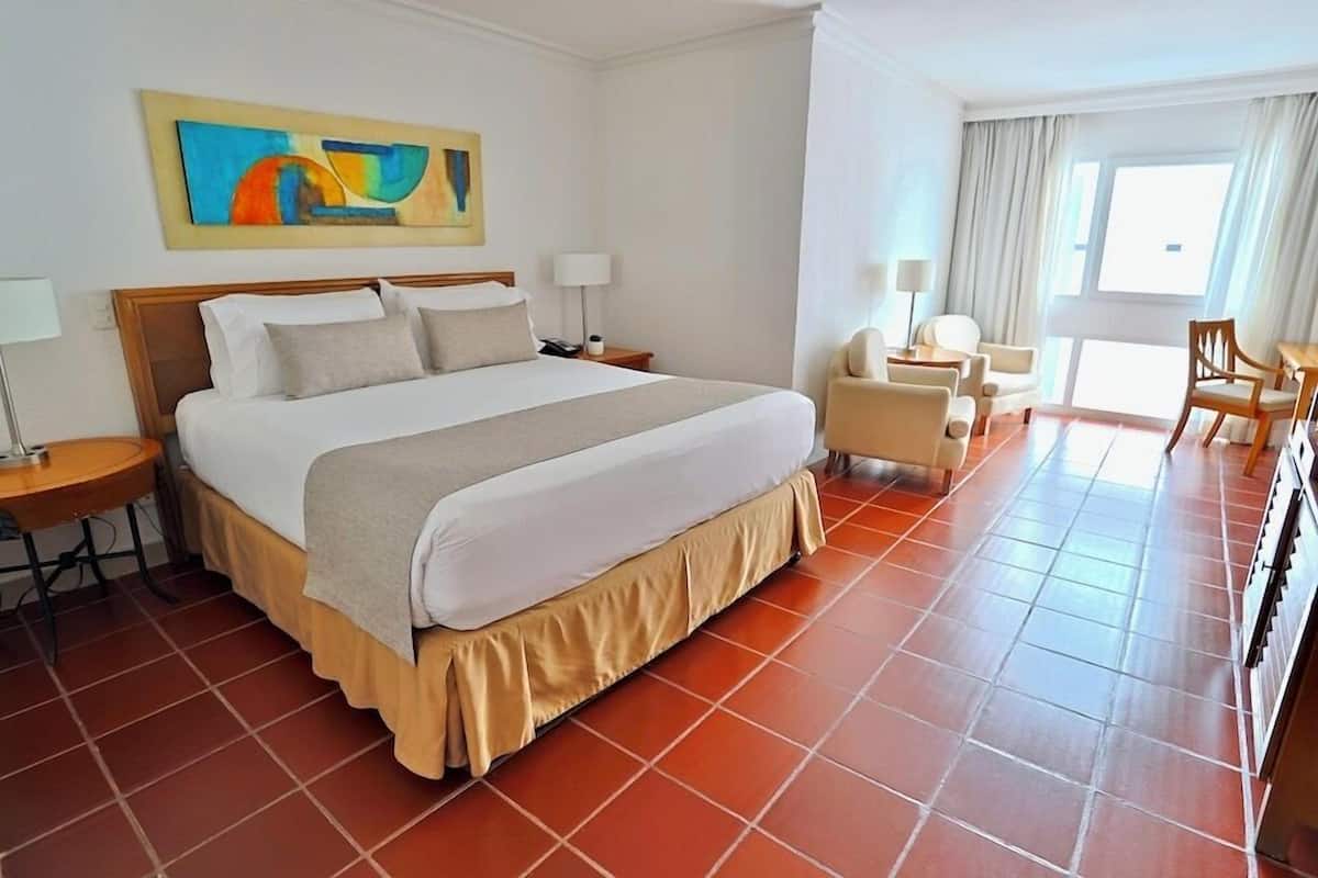 Hotelkamer met een groot bed, een bureau, een stoel en uitzicht op het buitenland.