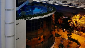 Un hotel moderno con piscina y vistas al océano al atardecer.