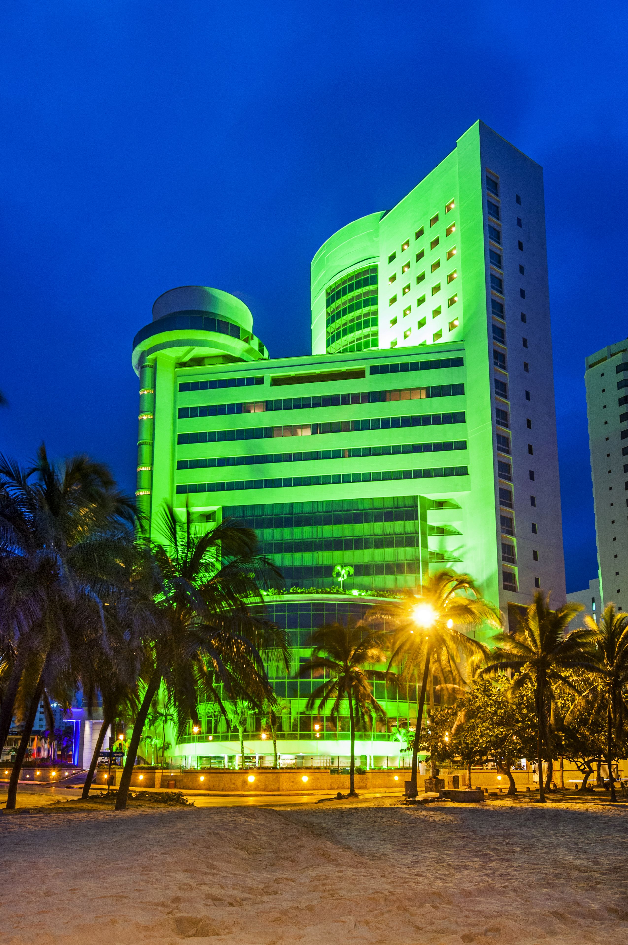 A multi-story hotel with a modern design, featuring a prominent curved structure and a series of balconies.