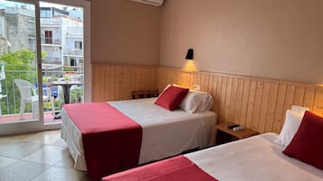 Una habitación de hotel con dos camas, un balcón y aire acondicionado.