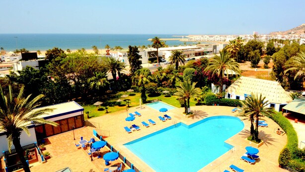 A resort with a swimming pool, sun loungers, and palm trees. - Oasis Hôtel & Spa (Agadir)