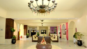 A spacious lobby with a central round seating area, a chandelier, and a reception desk in the background. - Oasis Hôtel & Spa (Agadir)
