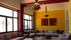 A modern living room with a sofa set, a coffee table, and a chandelier. - Oasis Hôtel & Spa (Agadir)