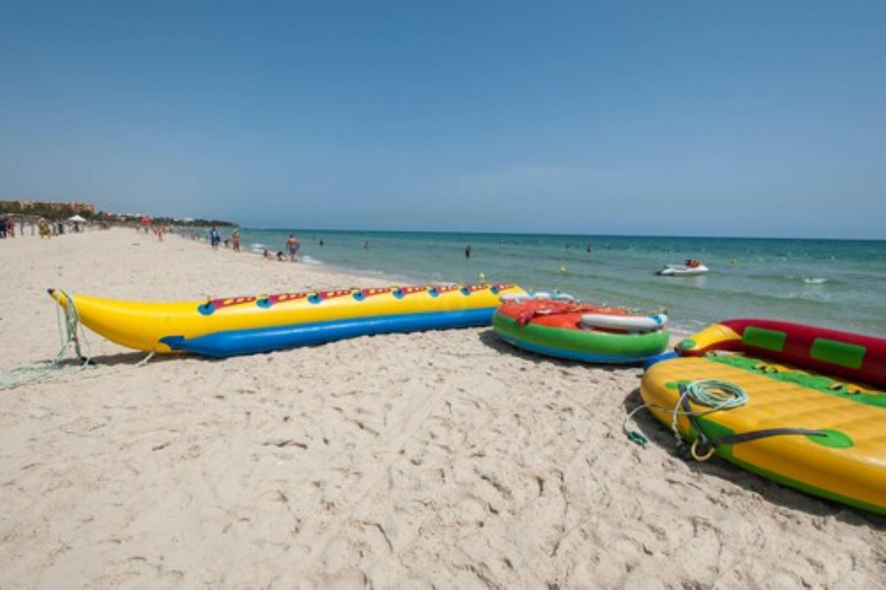Een strand met luchtbedden en een heldere lucht.