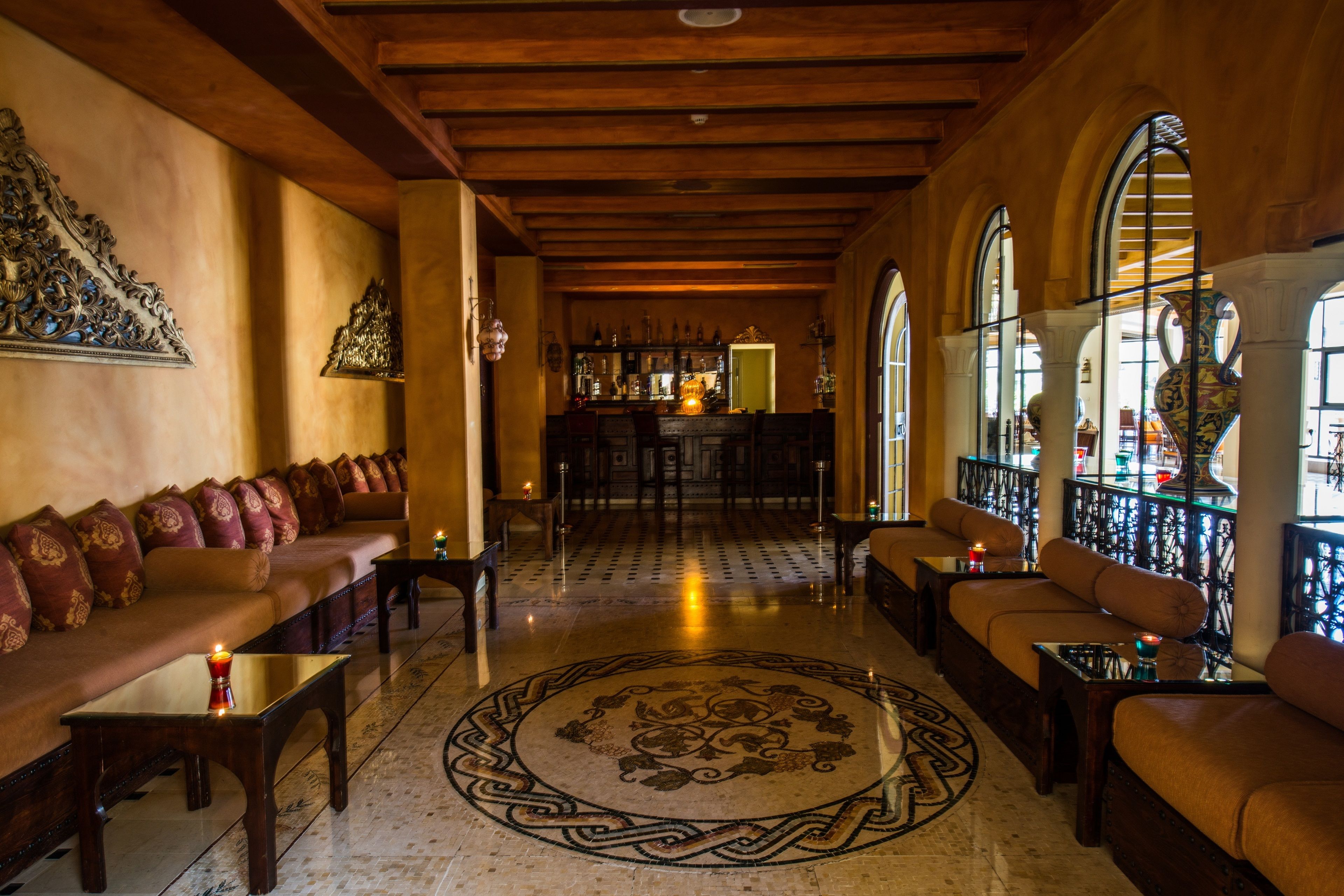 Un hall d’entrée spacieux avec un bar, des sièges confortables et un motif décoratif sur le sol.