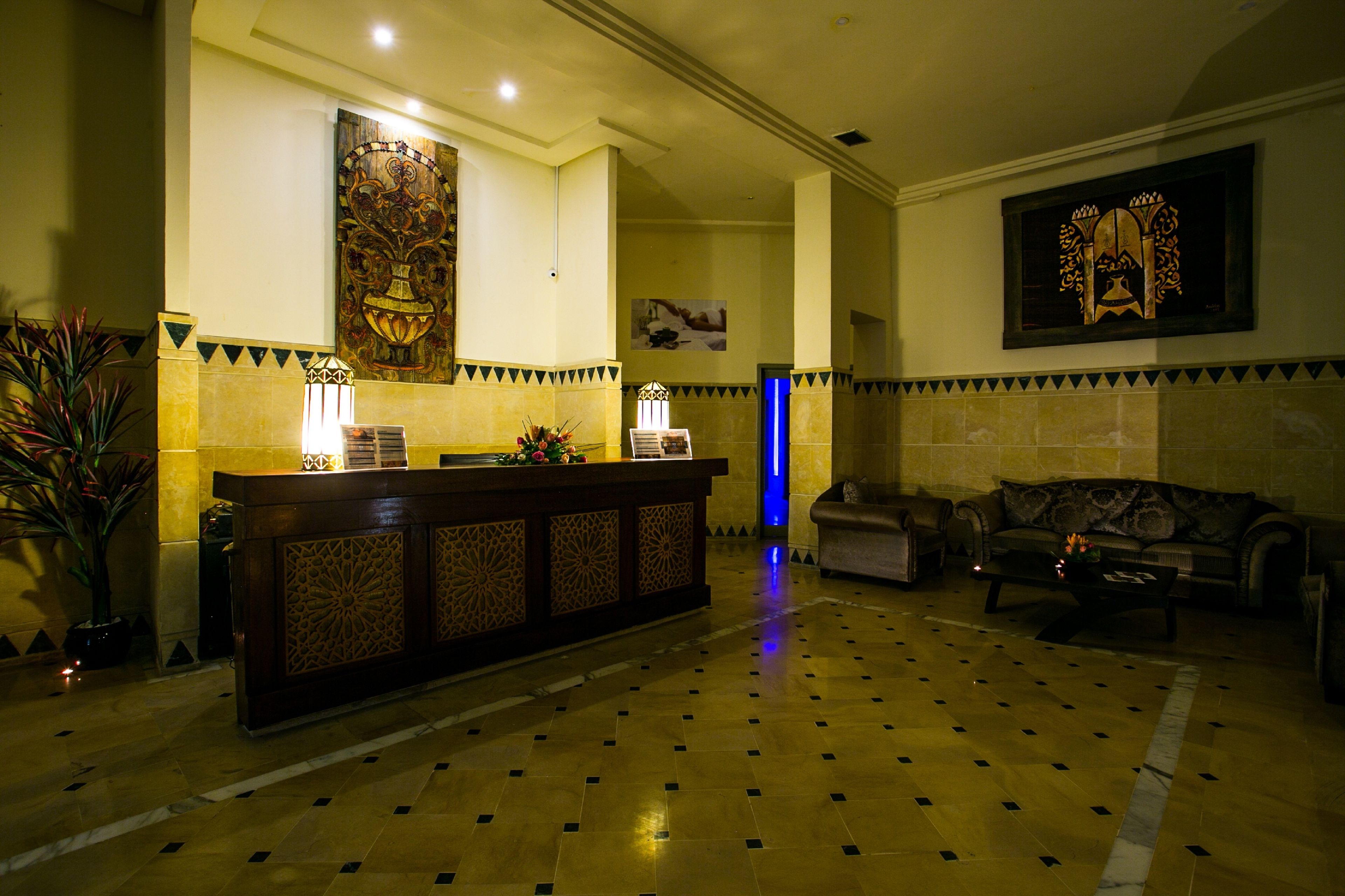 Eine Lobby mit einer Rezeption, einer Couch und einem gemusterten Boden.