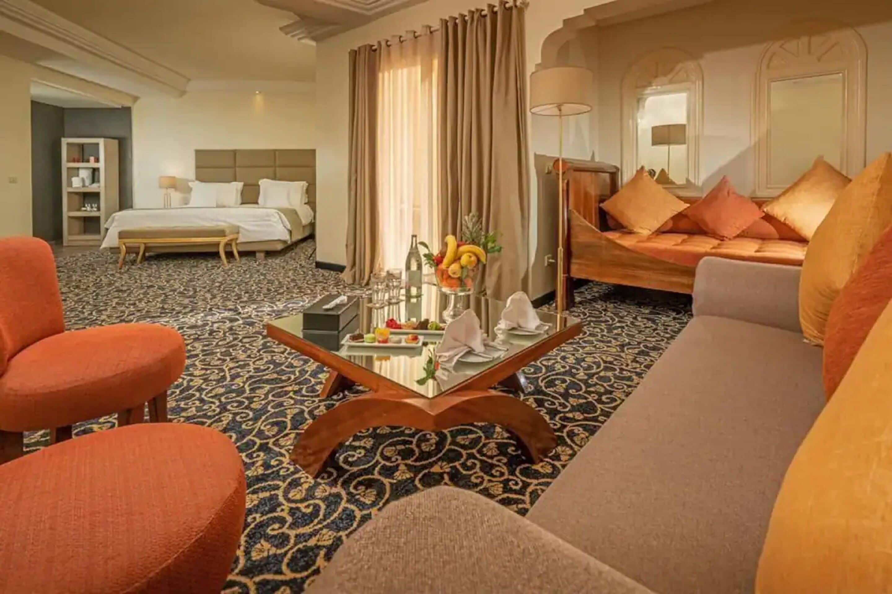 Una habitación de hotel con cama, sofá, mesa de centro y una silla.