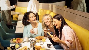 A group of people dining in a restaurant with yellow booths and a casual atmosphere.