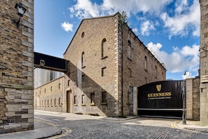 A historic brick building with a large black sign reading "GUINNESS St. James Gate Brewery, Dublin."
