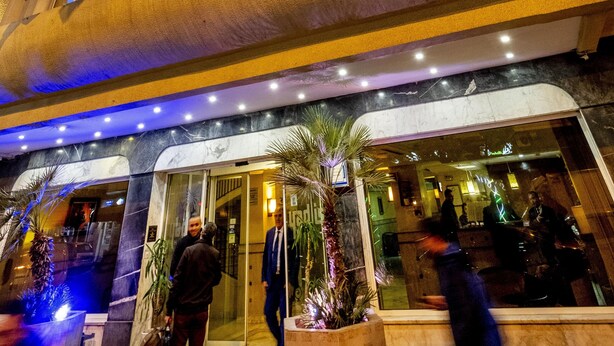 Un hotel con un letrero llamativo, una fachada moderna y una entrada bien iluminada.