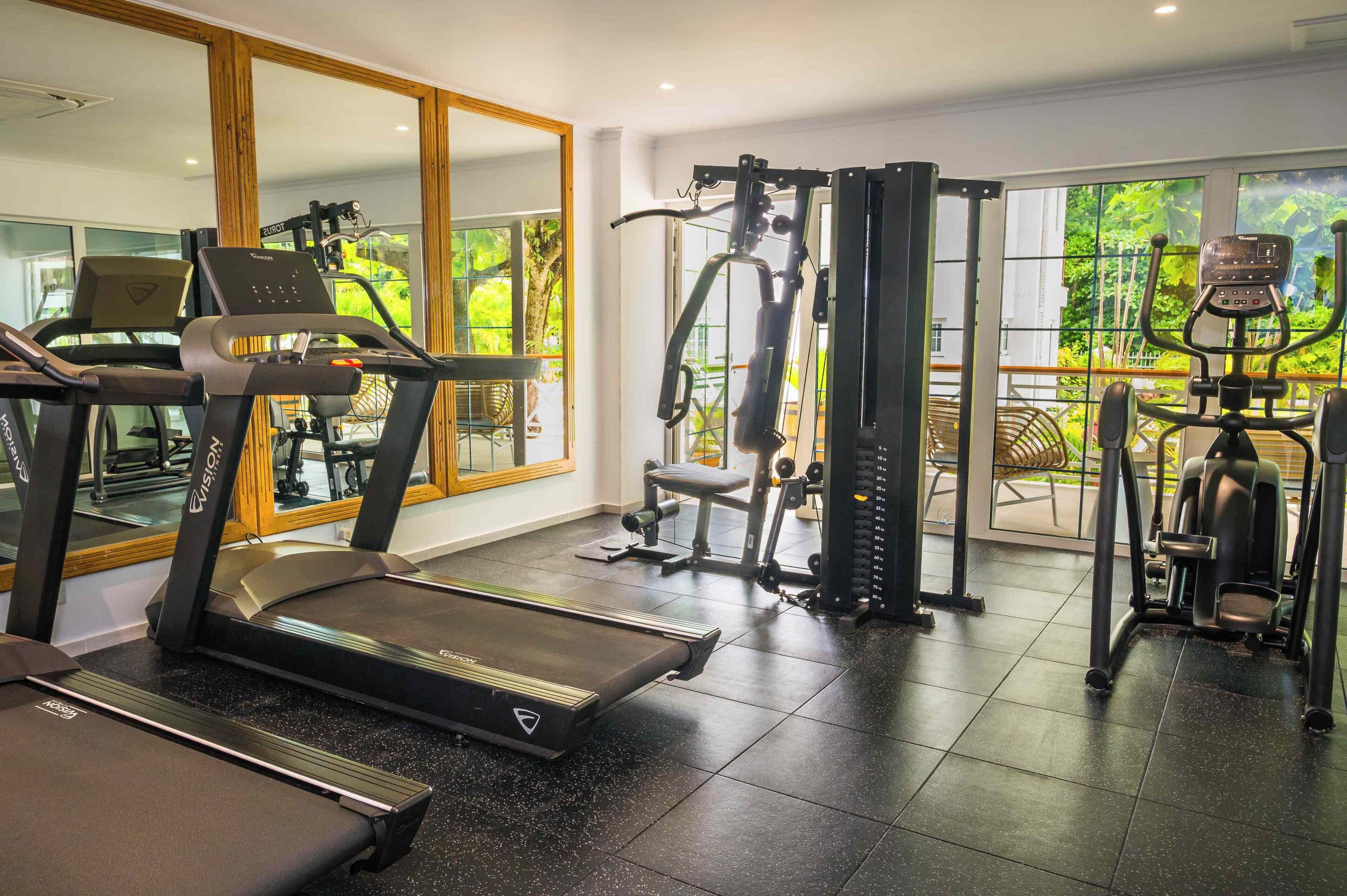 A gym with treadmills, weight machines, and a mirror.