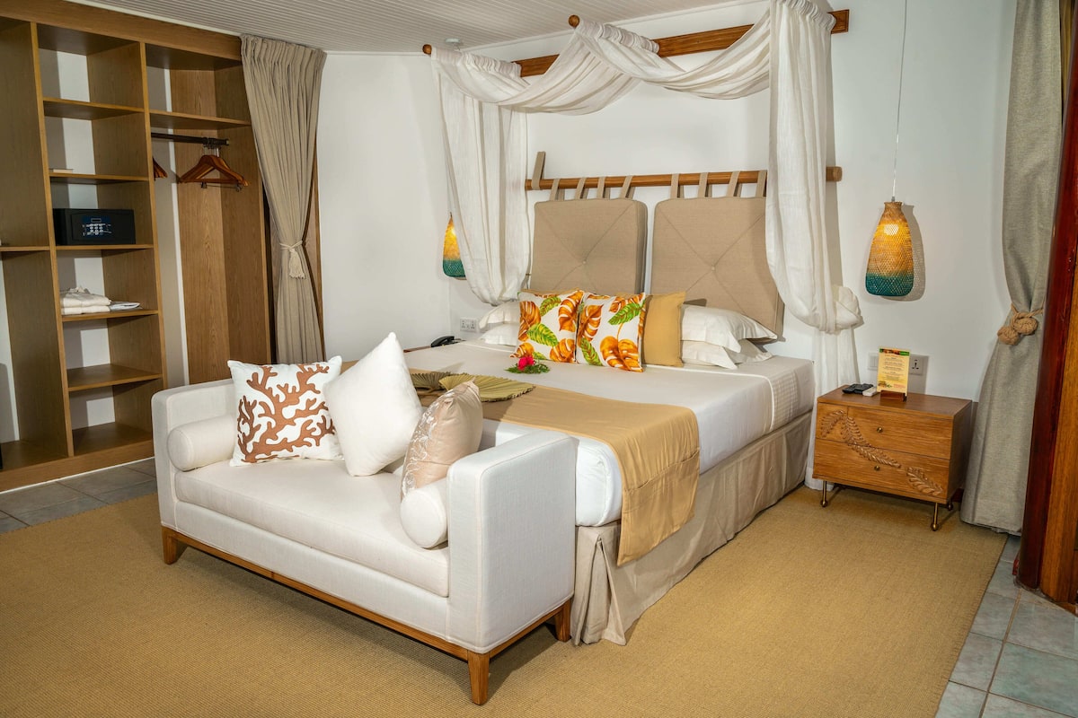 A bedroom with a bed, a sofa, a nightstand, and a wardrobe.