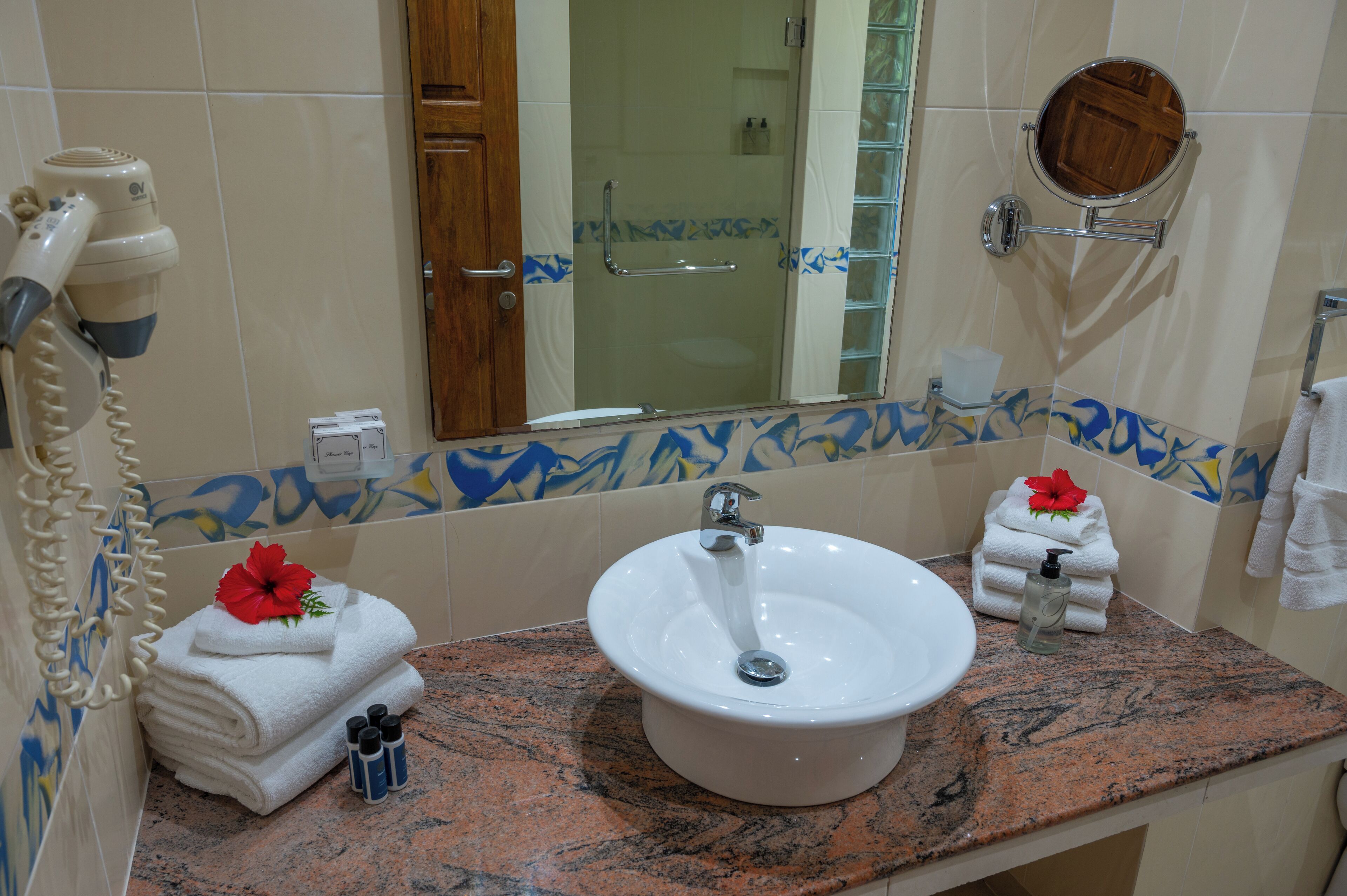 A bathroom with a sink, mirror, and towel rack.