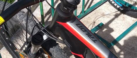 A bicycle secured to a metal rack outdoors.