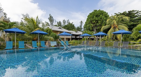 Outdoor pool, pool umbrellas, sun loungers. Acajou Beach Resort