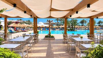 Un espace aménagé au bord de la piscine, avec des sièges et des parasols.