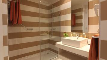 Ein modernes Badezimmer mit Duschkabine aus Glas, Waschbecken in Weiß und gestreiften Wandfliesen.